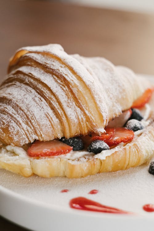 A croissant with fruits and sweet cream cheese